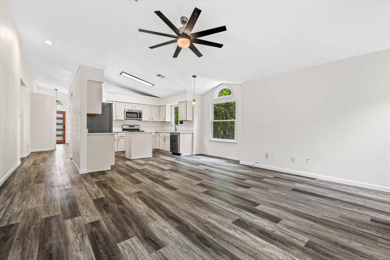 4004 Danli Lane Austin, TX 78749 - Photo 19 of 40 a view of a kitchen with a stove cabinets a ceiling fan and wooden floor