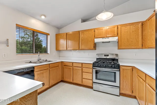 a kitchen with a stove a sink and a window