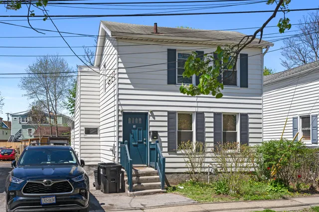 a view of a house with a small space and wooden deck