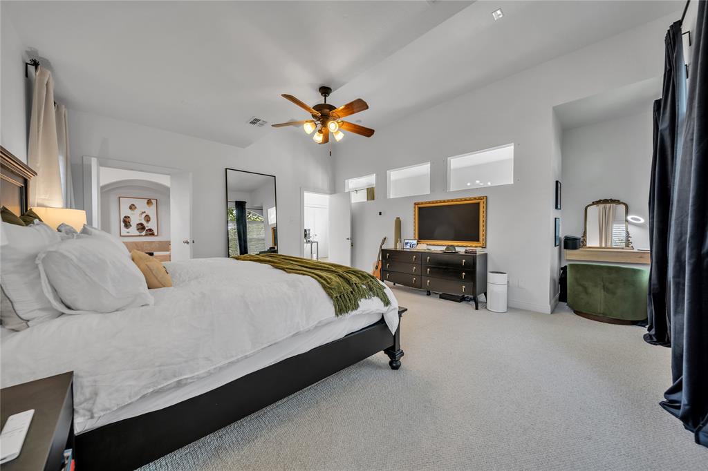 4317 Cedar Springs Road, Unit A Dallas, TX 75219 - Photo 11 of 27 a spacious bedroom with a bed a ceiling fan and a flat screen tv