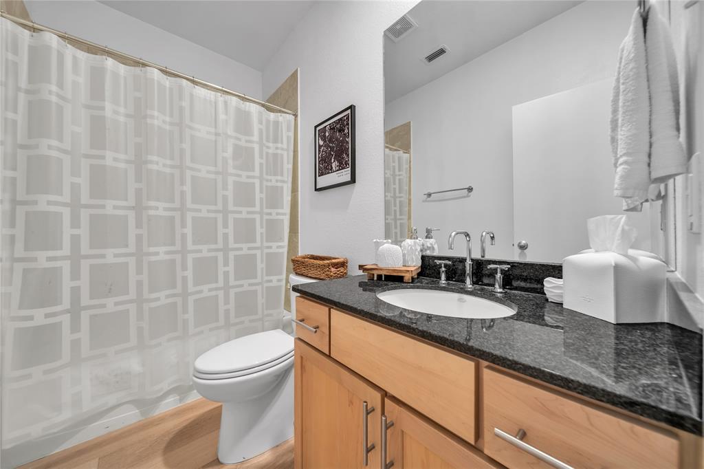 4317 Cedar Springs Road, Unit A Dallas, TX 75219 - Photo 20 of 27 a bathroom with a granite countertop sink a toilet and a mirror