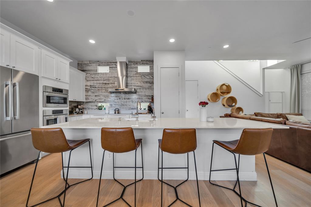 4317 Cedar Springs Road, Unit A Dallas, TX 75219 - Photo 4 of 27 a kitchen with stainless steel appliances kitchen island granite countertop a dining table chairs stove and white cabinets