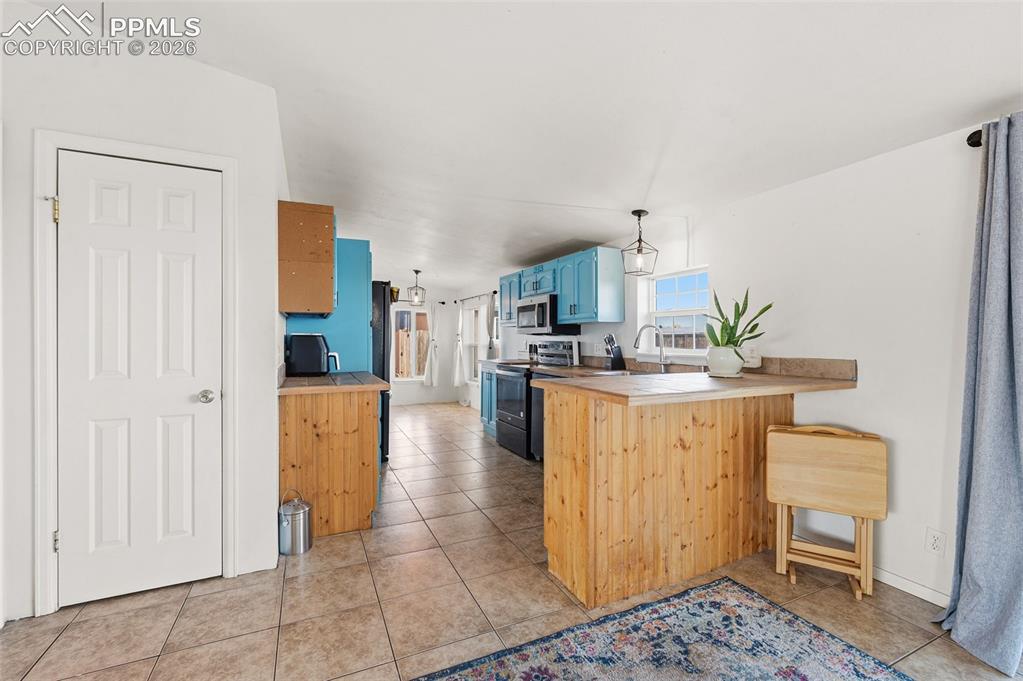 5535 Peerless Farms Road Peyton, CO 80831 - Photo 8 of 27 a kitchen with stainless steel appliances a refrigerator a sink a stove top oven