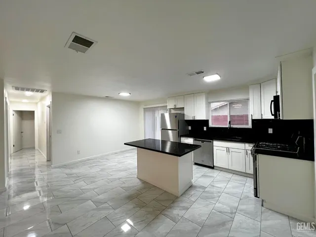 a kitchen with a sink and white cabinets