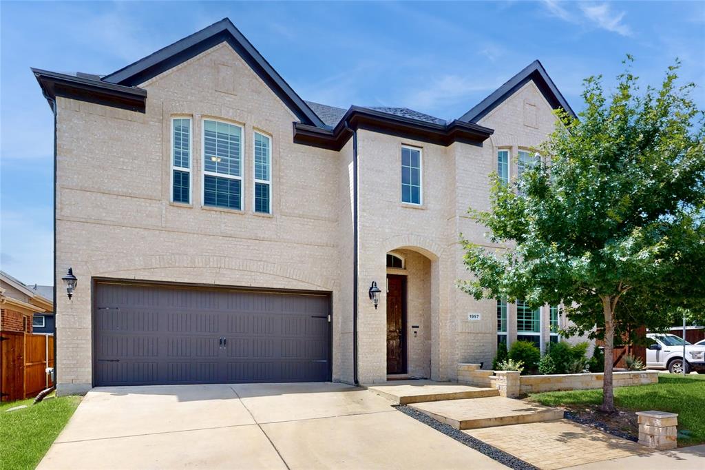 View of front of home with brick siding, a garage, and concrete driveway