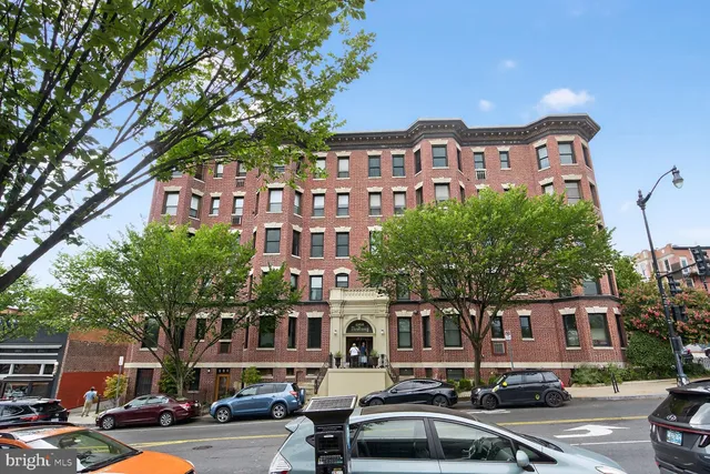 a couple of cars parked in front of brick building