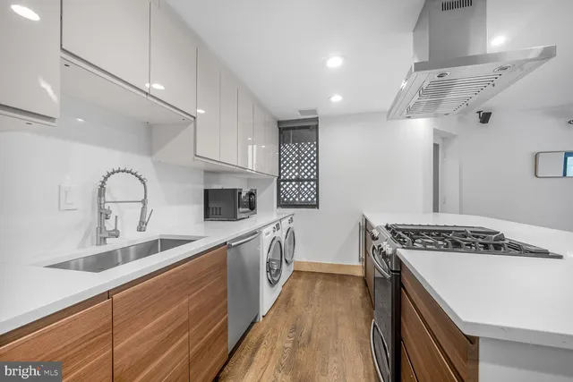 a kitchen with kitchen island stainless steel appliances a sink stove and cabinets