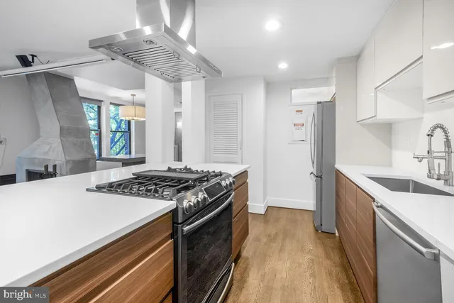 a kitchen with stainless steel appliances a sink stove and cabinets