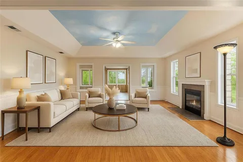 a kitchen with granite countertop a stove a sink and white cabinets with wooden floor