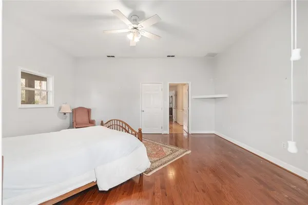 an empty room with wooden floor closet and windows