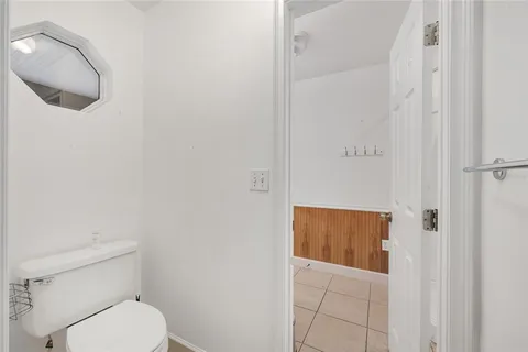 an empty room with wooden floor closet and windows