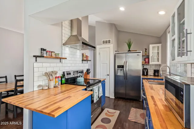 a kitchen with stainless steel appliances granite countertop a refrigerator a stove and a sink