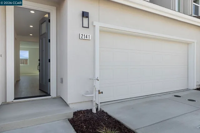 a view of a hallway with a white door and a cabinet