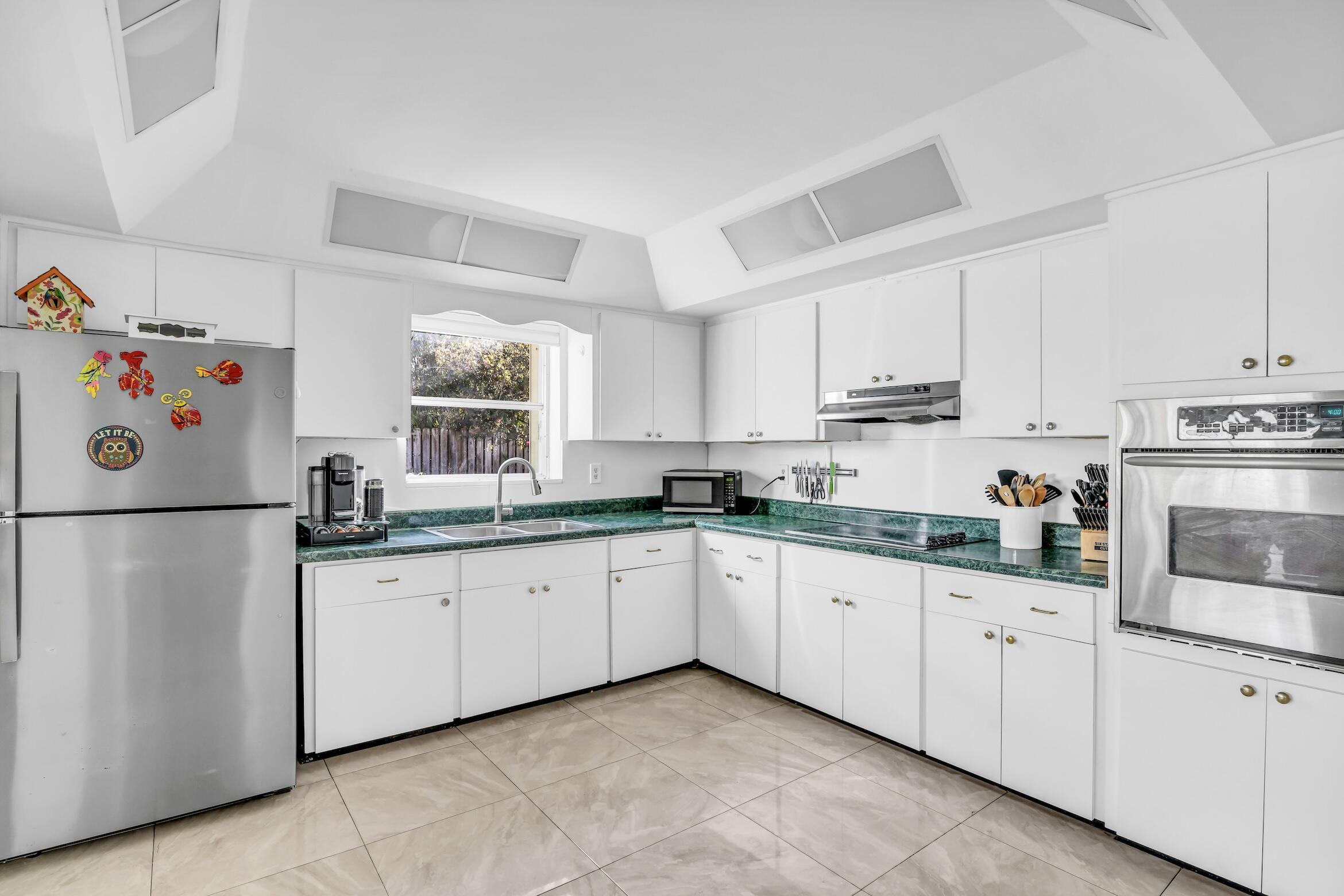 1290 Southwest 8th Street Boca Raton, FL 33486 - Photo 16 of 35 a kitchen with granite countertop white cabinets white stainless steel appliances and sink