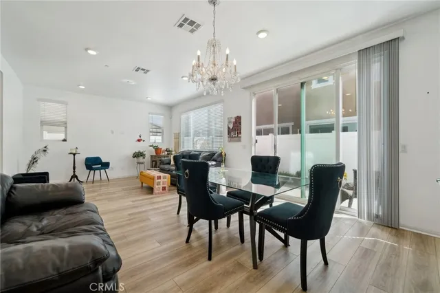a living room with furniture a chandelier and a floor to ceiling window