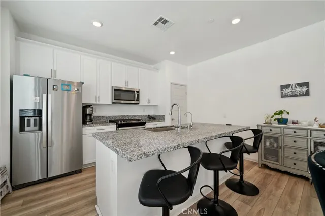 a kitchen with granite countertop a table chairs stove and refrigerator