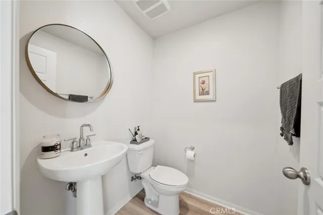 a bathroom with a toilet a sink and mirror
