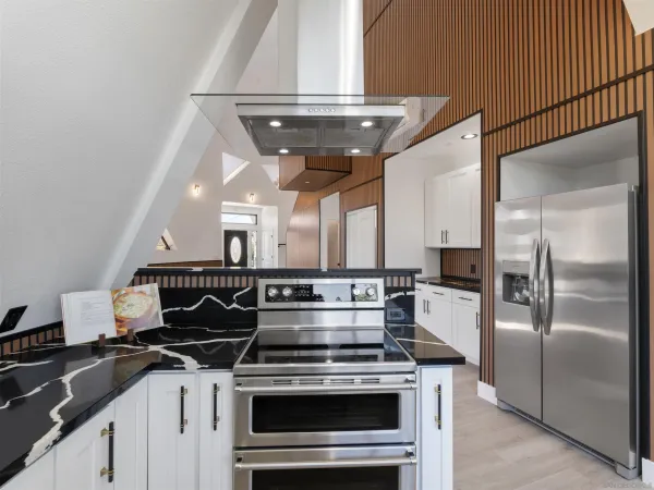 a kitchen with granite countertop a stove and a wooden floor
