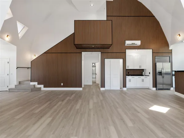 an empty room with wooden floor and a bathroom