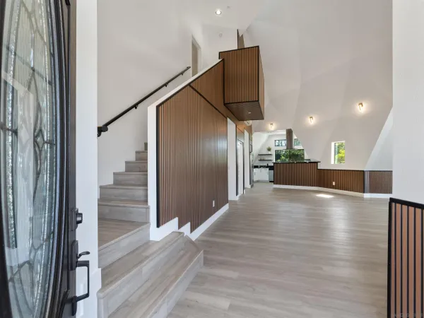 a view of a hallway with wooden floor and staircase