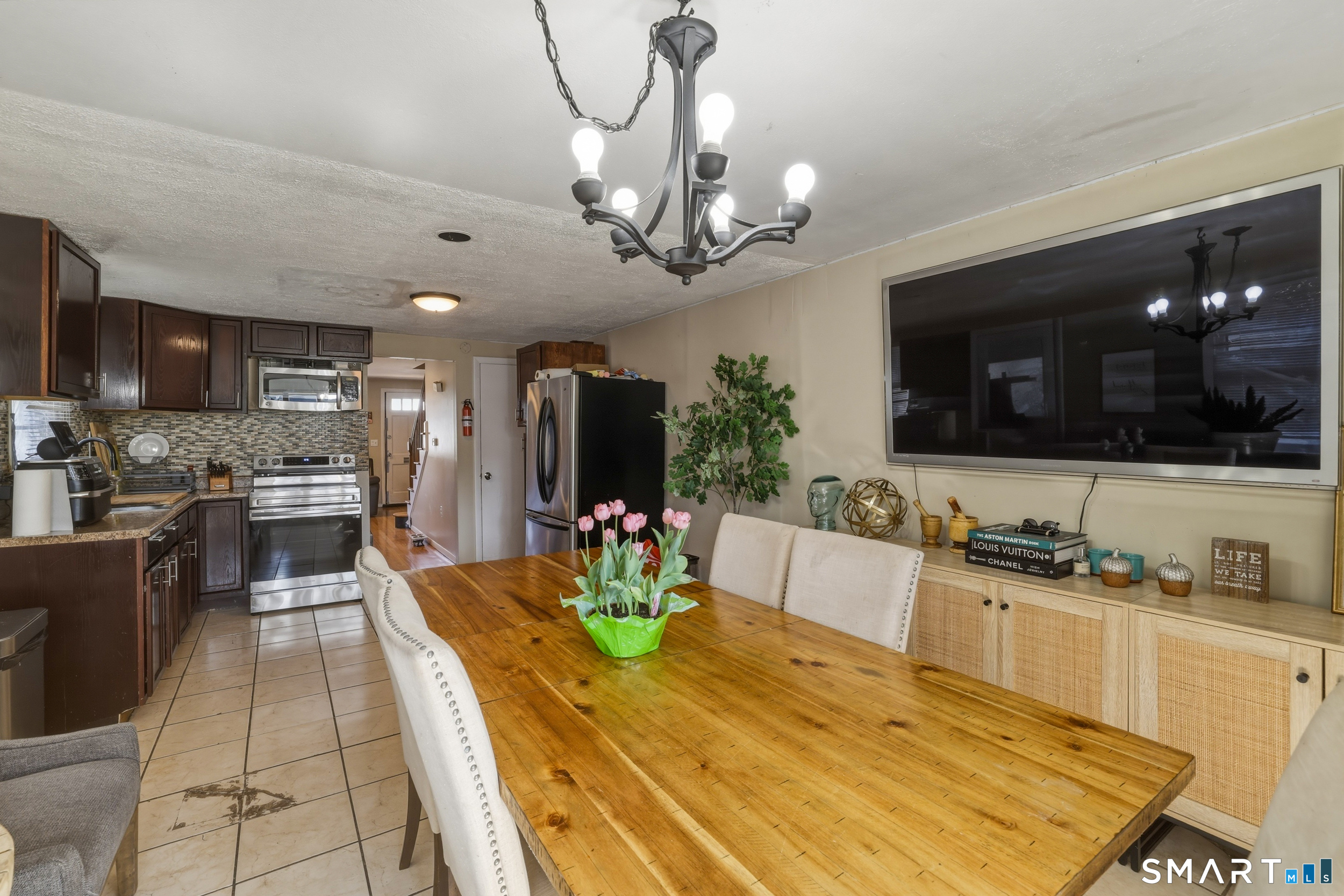30 Lyndale Street Manchester, CT 06040 - Photo 22 of 37 a kitchen with stainless steel appliances kitchen island granite countertop a refrigerator a stove a microwave oven a sink with a dining table and chairs