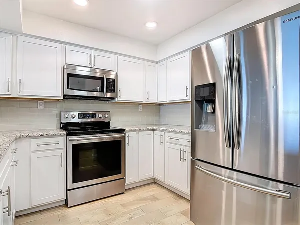 a kitchen with stainless steel appliances granite countertop a stove a sink and a refrigerator