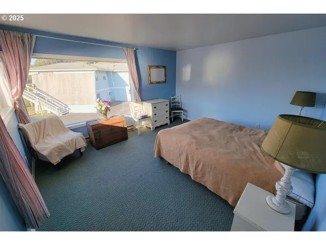 a bedroom with bed and a painting on the wall