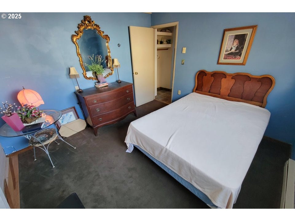 1816 Maxwell Mountain Road Oceanside, OR 97134 - Photo 18 of 18 a bedroom with bed and a painting on the wall