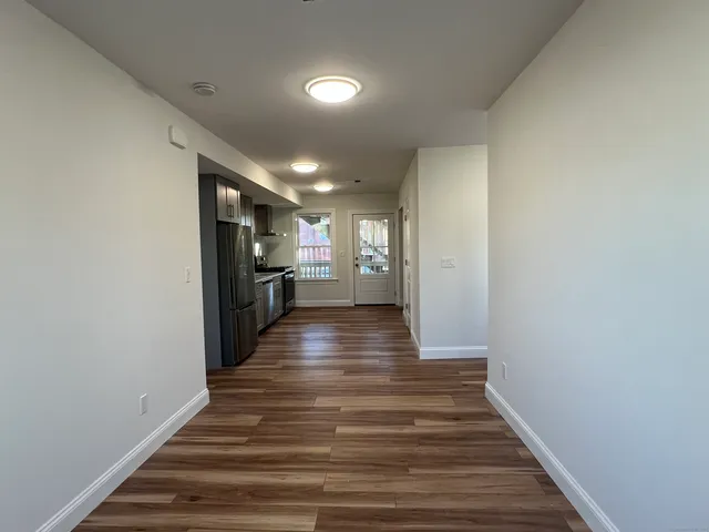 a view of a hallway with wooden floor