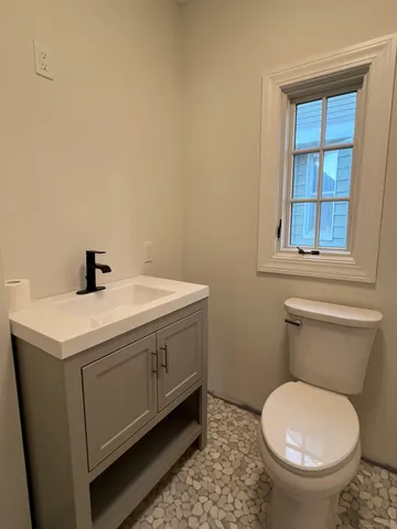 a bathroom with a sink toilet and window