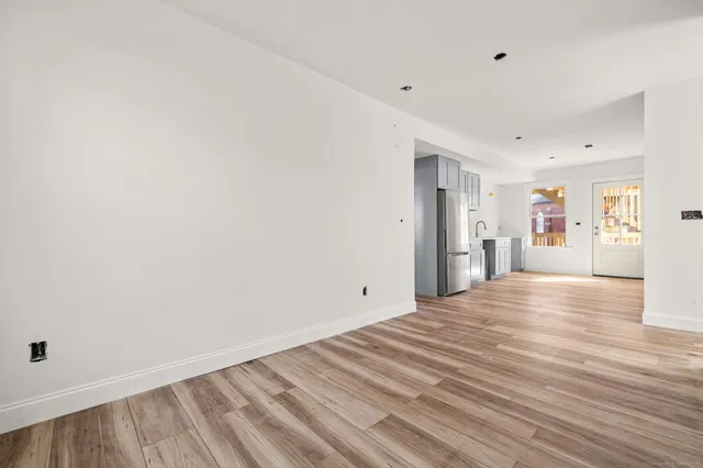 a view of empty room with wooden floor