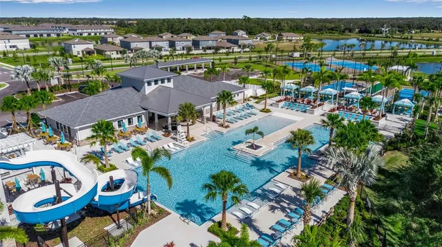 a kitchen with stainless steel appliances granite countertop a stove top oven a sink dishwasher a dining table and chairs with wooden floor