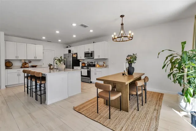 a spacious bedroom with a bed a chandelier and a window