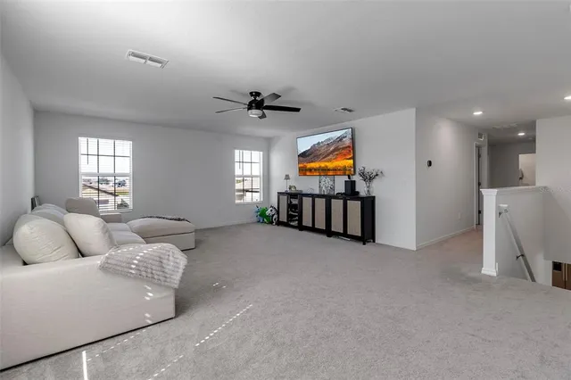 a large living room with kitchen island granite countertop wooden floor and a rug