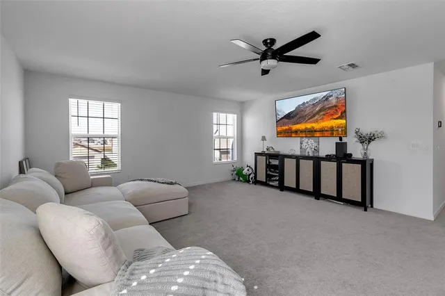 a living room with lots of furniture and view of kitchen