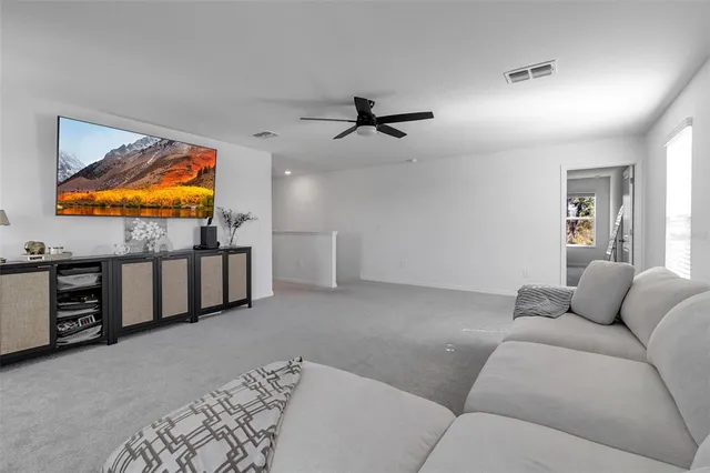 a living room with patio furniture and a floor to ceiling window
