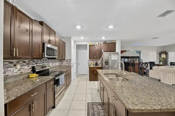 a kitchen with stainless steel appliances a stove a sink a refrigerator and a oven