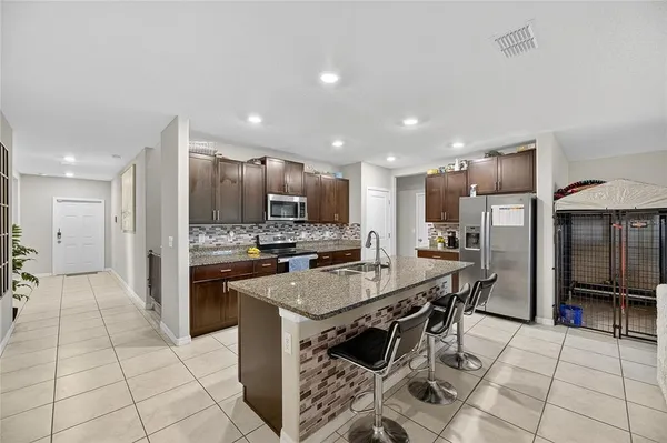 a kitchen with stainless steel appliances granite countertop a sink stove and refrigerator