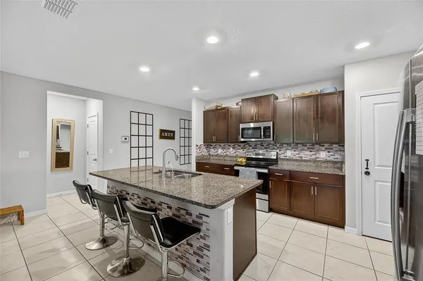 a living room with granite countertop furniture and a flat screen tv