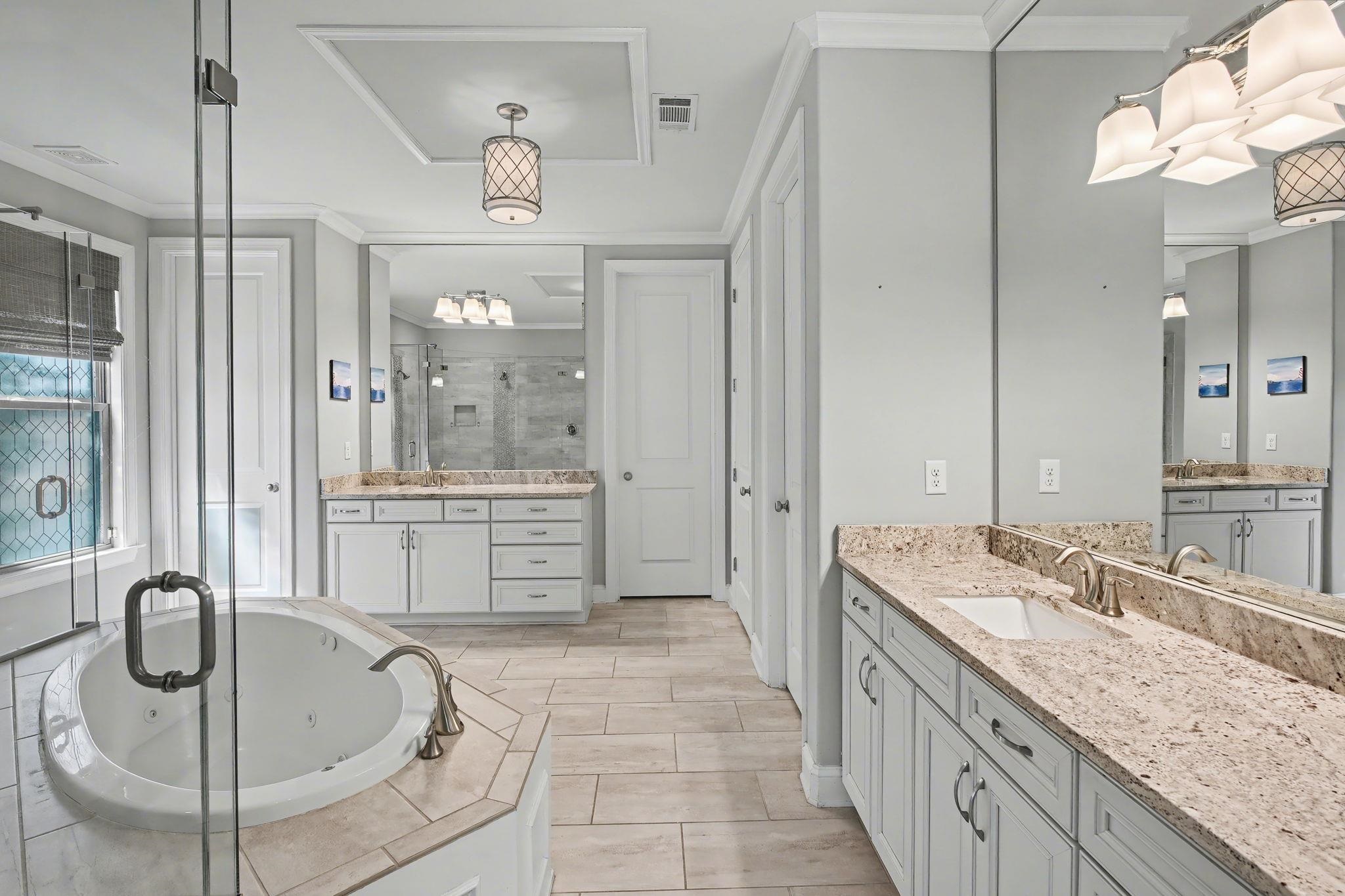 477 Fallen Timbers Cove Collierville, TN 38017 - Photo 18 of 40 a spacious bathroom with a granite countertop sink a mirror a bathtub and shower