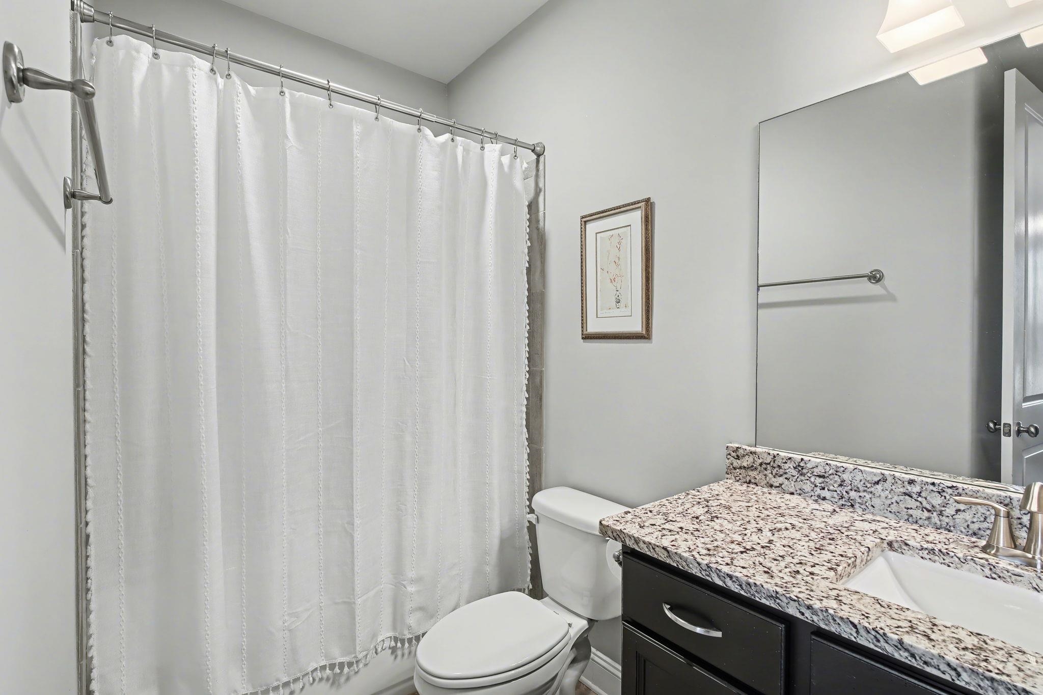 477 Fallen Timbers Cove Collierville, TN 38017 - Photo 25 of 40 a bathroom with a granite countertop sink toilet and a mirror