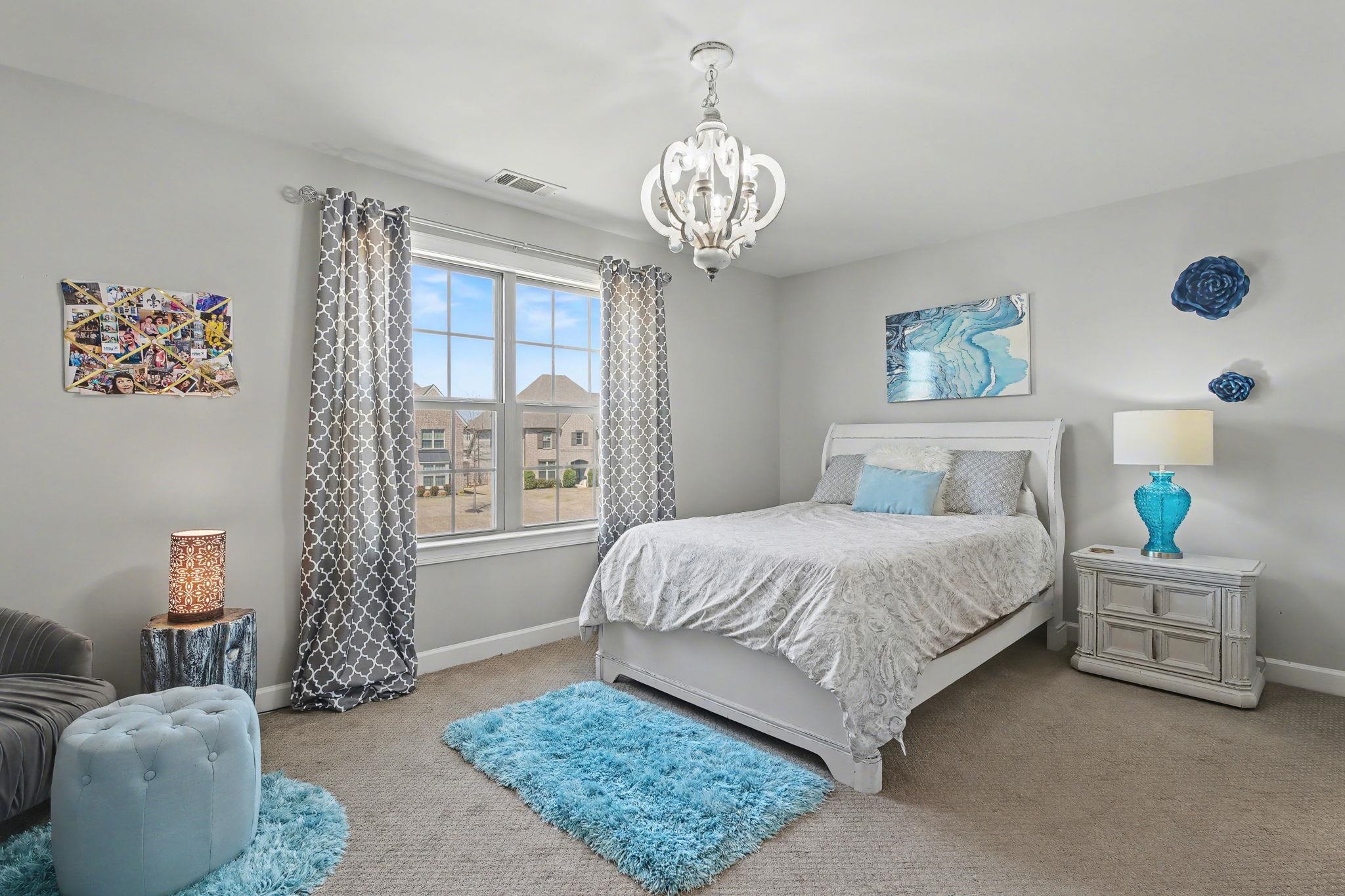 477 Fallen Timbers Cove Collierville, TN 38017 - Photo 32 of 40 a bedroom with a bed and a chandelier