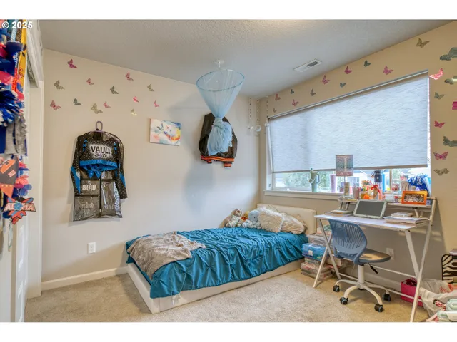 a bedroom with a bed and a chair in it