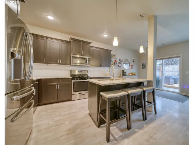 a kitchen with kitchen island a sink stove and refrigerator