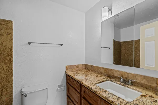 a bathroom with a granite countertop sink and a mirror