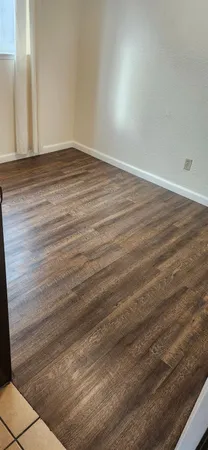 a view of an empty room with wooden floor