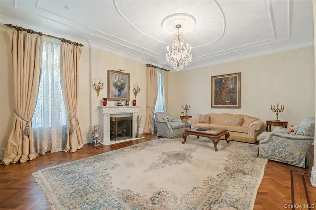 a living room with furniture a fireplace and a chandelier