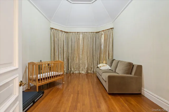a bed sitting in a spacious bedroom next to a window