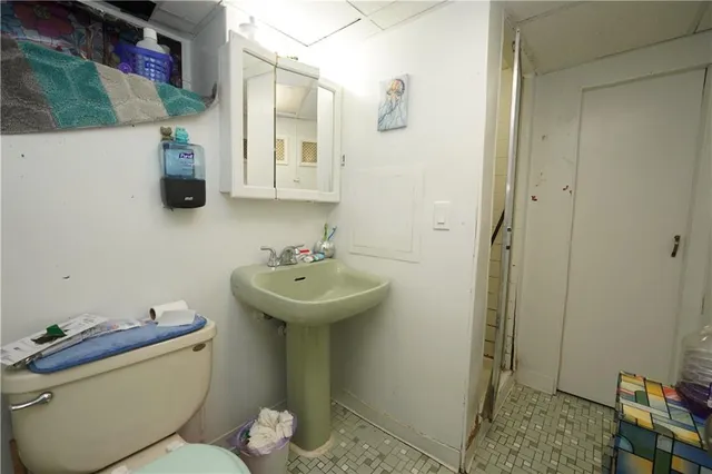 a bathroom with a sink and mirror with toilet