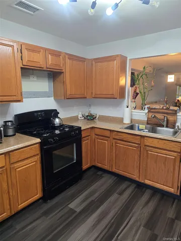 a kitchen with granite countertop a sink cabinets and stainless steel appliances